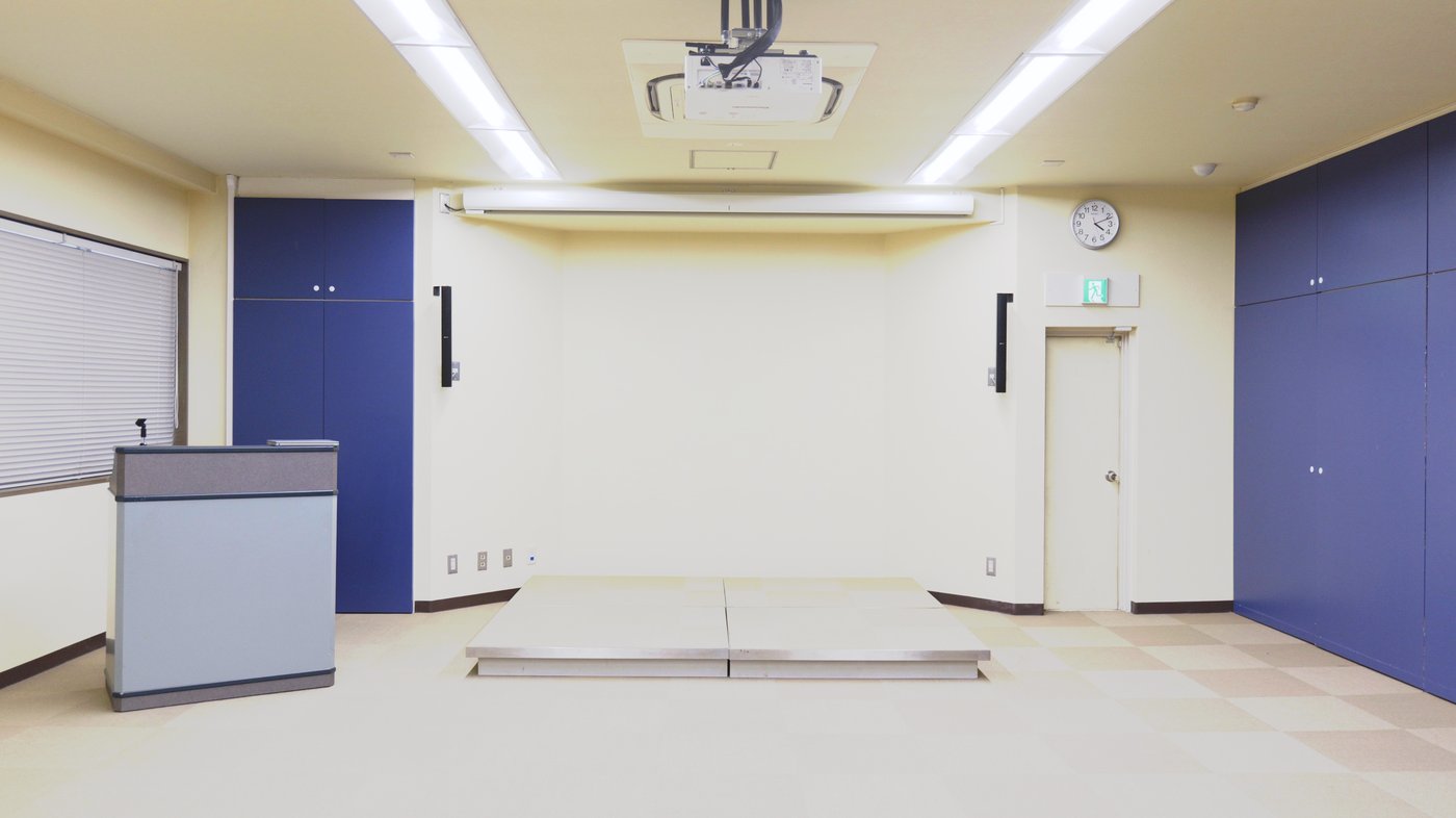 大熊本証券 本社6階ホール全景 ― 演台・ステージ・KGEARラインアレイスピーカー・プロジェクター